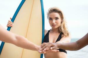 retrato do sorridente jovem mulher dentro bikini com prancha de surfe às de praia foto