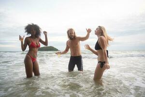 grupo do amigos tendo Diversão em a de praia. jovem mulheres tendo Diversão em a de praia. foto