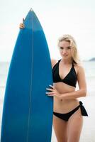 surfista menina com dela prancha de surfe em a de praia. foto