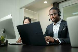 grupo do o negócio pessoas vestindo fone de ouvido trabalhando ativamente dentro escritório. ligar Centro, telemarketing, cliente Apoio, suporte agente providenciar serviço em Telefone vídeo conferência chamar. foto