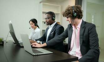 grupo do o negócio pessoas vestindo fone de ouvido trabalhando ativamente dentro escritório. ligar Centro, telemarketing, cliente Apoio, suporte agente providenciar serviço em Telefone vídeo conferência chamar. foto