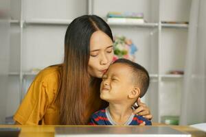 feliz mãe e filho às casa escrivaninha foto