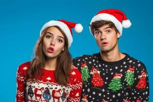 uma fechar acima foto do uma jovem casal vestindo Natal blusas e santa chapéus em pé sozinho em uma azul fundo, ai generativo