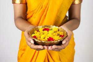 uma foto do uma lindo maduro indiano mulher segurando calêndula flores dentro uma prato enquanto a comemorar a festival do luzes, ai generativo