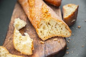 saboroso baguete fresco pão grandes pão lanche Aperitivo refeição Comida em a mesa cópia de espaço Comida fundo rústico topo Visão foto