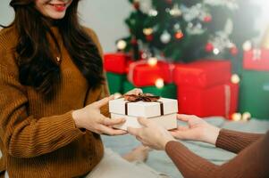 mulher feliz dando caixa de presente de natal e ano novo para mulher em home.family celebração de natal. Decoração de Natal. foto