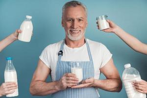 positivo, sênior homem segurando um copo de leite foto