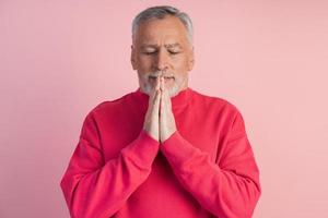 homem de olhos fechados medita sobre um fundo rosa foto