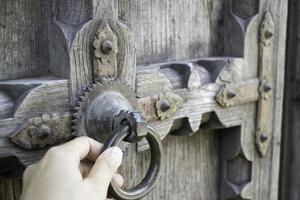 velha porta de madeira aberta com padrão esculpido foto