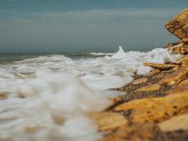 bela praia com muitas pedras do mar de diferentes tamanhos foto