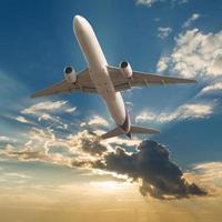 avião comercial voando com nuvens e fundo de raios de sol foto