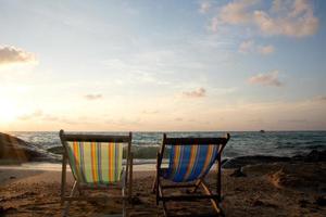 espreguiçadeiras de férias de verão em praia tropical foto
