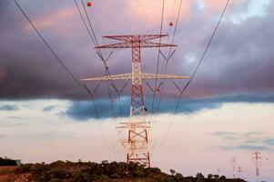 uma ampla elétrico torre com nuvens dentro a fundo foto