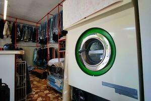 uma lavanderia quarto com uma lavando máquina e roupas foto
