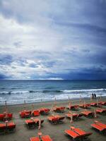 foto do uma vibrante de praia cena com uma grupo do laranja cadeiras negligenciar a oceano