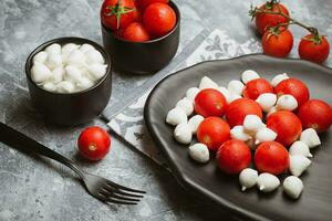 clássico italiano salada caprese servido dentro original Formato com cereja tomates, mini mussarela pérolas, manjericão folhas e balsâmico Esmalte foto