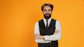 chique mordomo em amarelo fundo estúdio, posando com confiança antes servindo jantar Como bem jantar restaurante pessoal. formal servidor trabalhando dentro refeições indústria, barbudo garçom dentro terno. foto