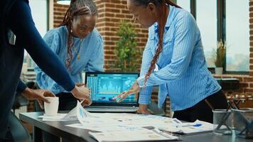 trabalhadores discutindo sobre anual relatórios, analisando executivo Estatisticas com computador portátil e arquivos. o negócio parceiros encontro dentro sala de reuniões para crio profissional projeto para desenvolvimento. foto