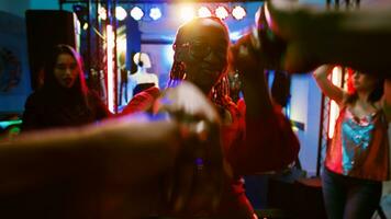 pov do mulher dançando com homem às festa, desfrutando discoteca música em dança chão. diverso pessoas tendo Diversão às Boate ouvindo para funky batidas, social encontro celebração. portátil tomada. foto