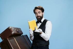 Mensageiro de hotel recita poesia a partir de livro, vestindo formal vestuário e desfrutando palestra passatempo contra azul fundo. hotel porteiro lendo literatura Páginas ou romance história, elegante funcionários membro. foto