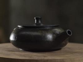 yixing pote de barro de cor preta após a queima em um suporte de madeira foto