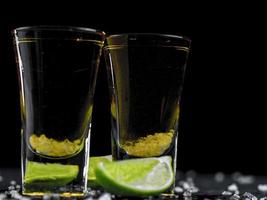 duas doses de tequila ouro com limão suculento e sal marinho foto