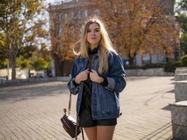 garota adolescente com cabelos soltos em uma jaqueta jeans ao ar livre foto