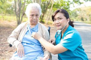 médico usando estetoscópio para verificar o paciente no parque foto