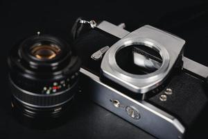 câmera de filme slr e uma lente em fundo preto, conceito de fotografia foto