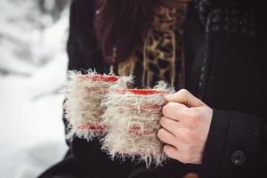 um rapaz e uma rapariga com roupas e lenços numa caminhada na neve foto