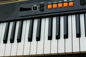 fechar-se do piano chaves. piano Preto e branco chaves e piano teclado musical instrumento colocada às a casa sacada durante ensolarado dia. foto