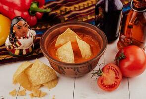 amarelo tortilla salgadinhos e salsa em branco mesa foto