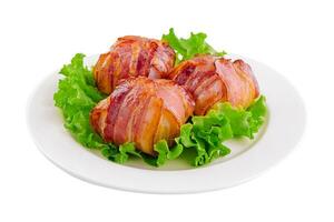 torcido rolos com bacon em branco prato foto