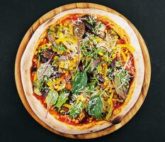 vegetariano pizza com Rúcula, beringela, cogumelos e milho foto