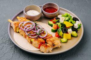 frango espetos com grego salada e cremoso, picante molhos foto