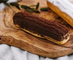 saboroso sobremesa, dois eclairs com baunilha e chocolate creme deitado foto