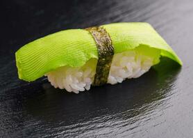 japonês Sushi conjunto com abacate em Preto madeira foto