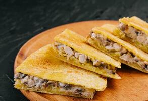 frango, cogumelo e queijo Quesadilla em de madeira borda foto