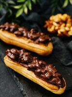 dois eclairs com Sombrio chocolate em Preto borda foto