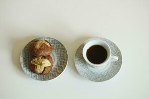 chocolate doce biscoitos e Preto café em uma servindo mesa foto