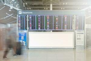 em branco Painel publicitário. com borrado imagem do pessoas caminhando dentro aeroporto terminal foto