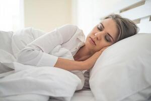 bela jovem dormindo na cama foto