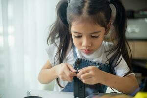 haste Educação conceito. ásia jovem menina Aprendendo robô Projeto. foto