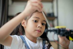 haste Educação conceito. ásia jovem menina Aprendendo robô Projeto. foto