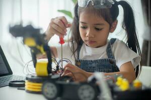 haste Educação conceito. ásia jovem menina Aprendendo robô Projeto. foto