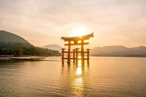 o portão flutuante do santuário itsukushima ao pôr do sol foto