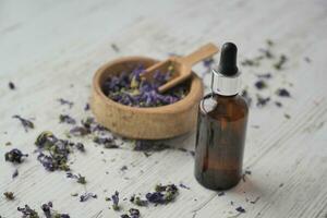 óleo essencial de lavanda e flores na mesa com espaço de cópia foto