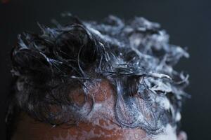 homens jovens lavam o cabelo com xampu. foto