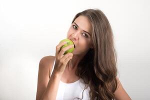 bela mulher segurando uma maçã verde enquanto isolada no branco foto