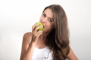 bela mulher segurando uma maçã verde enquanto isolada no branco foto